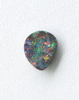 Multicolored opal stone on a white textured background