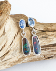 Opal earrings on a piece of driftwood