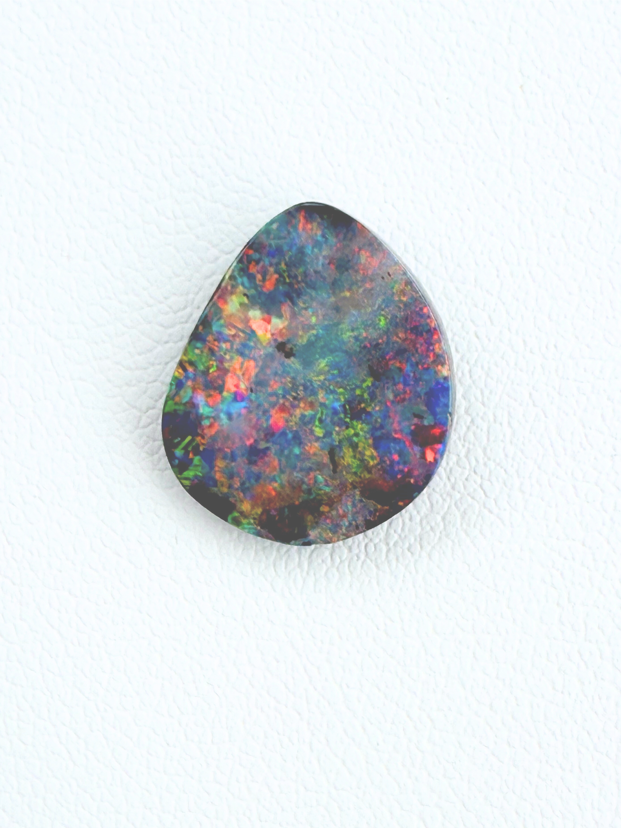 Multicolored opal stone on a white background