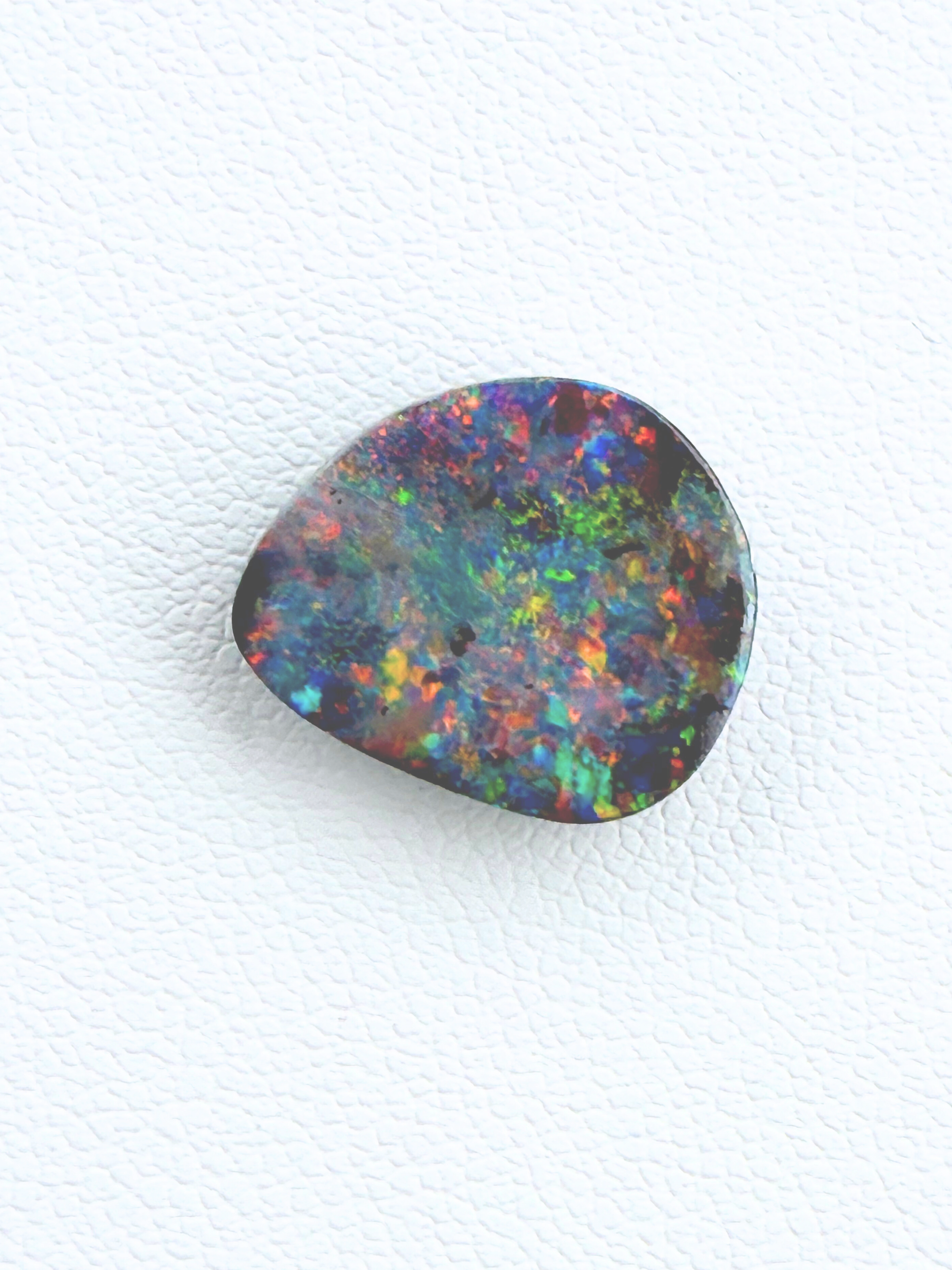 Multicolored opal stone on a white background
