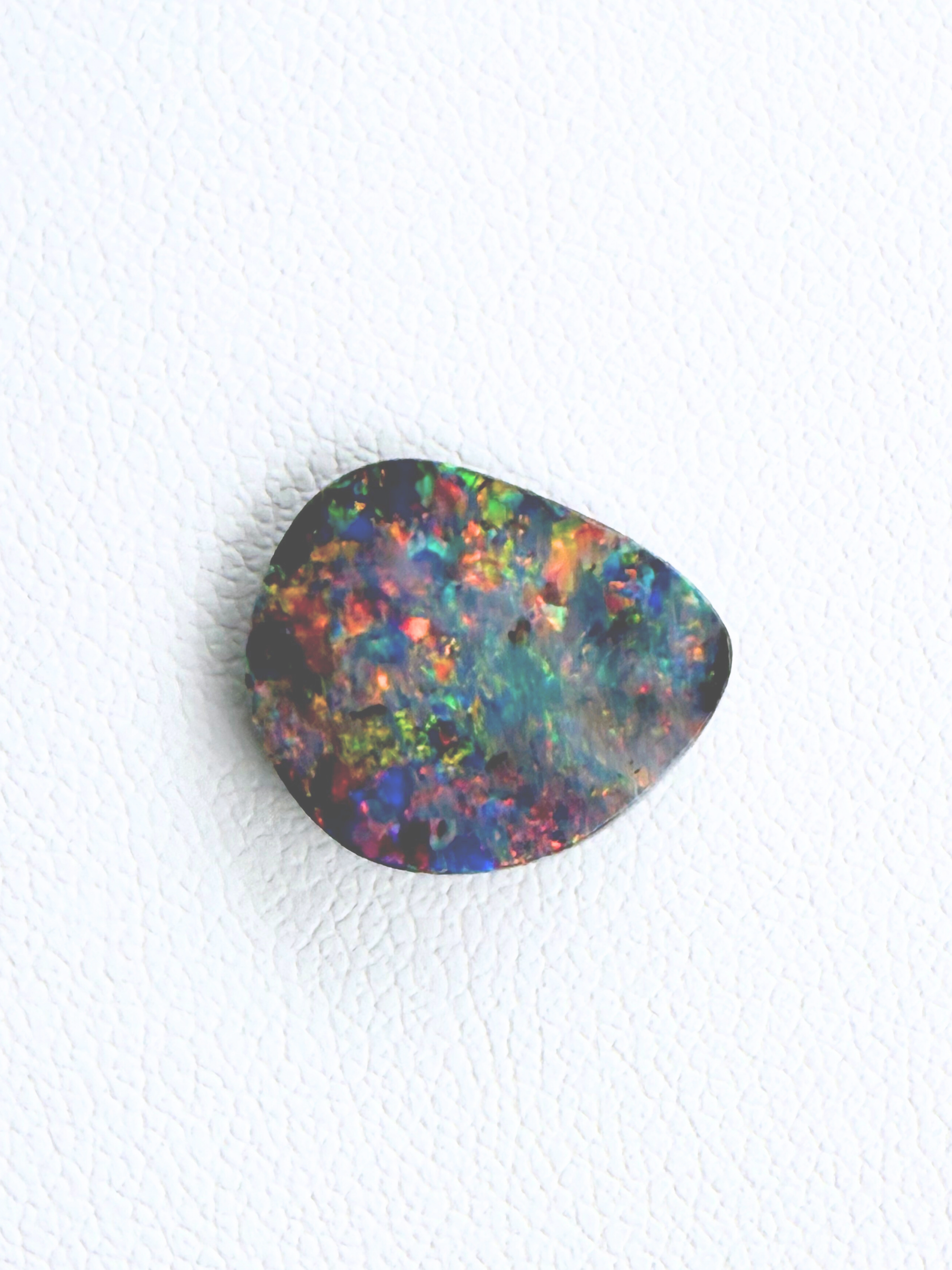 Multicolored opal stone on a white background